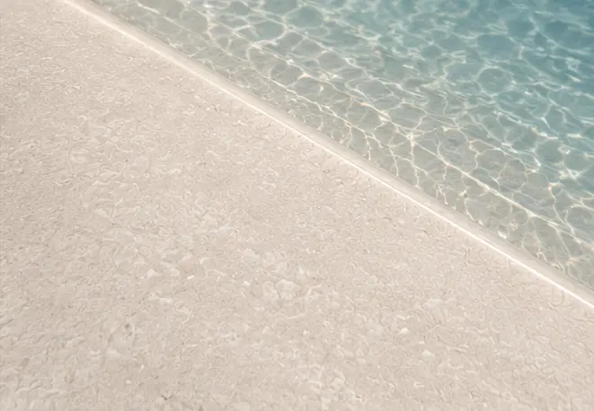 Detalle de Arelite Polish, revestimiento continuo de cuarzo y mármol con acabado pulido para piscinas.