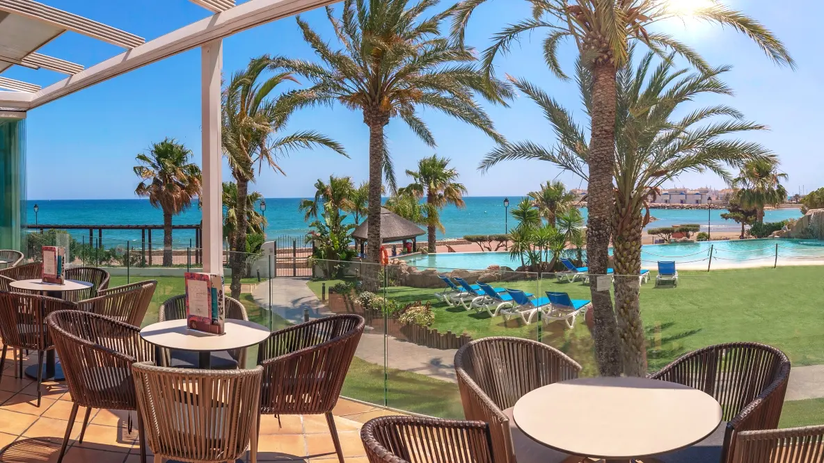 Terraza de hotel con vistas a piscina de arena y al mar